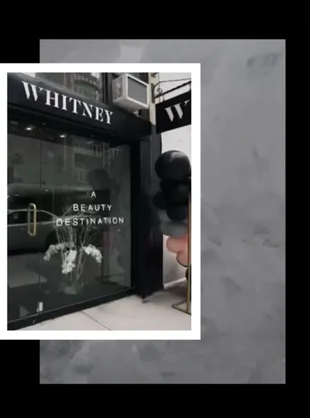 The WHITNEY Manhattan storefront, with 'a beauty destination' lettered on the window, framed in white on grey concrete